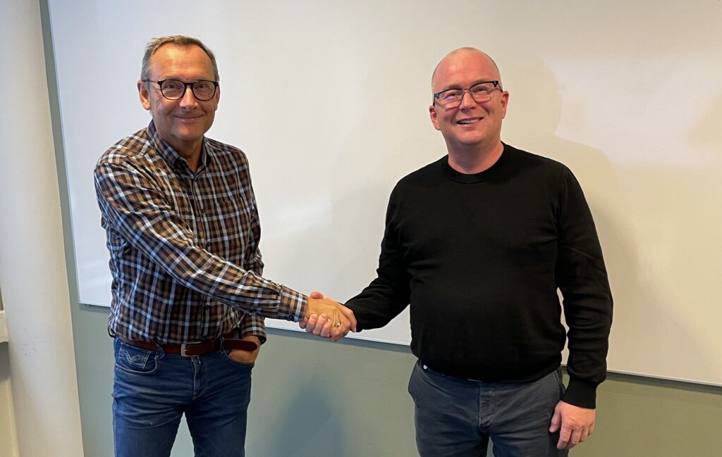 Representanter fra Blix Datagulv og OneCo håndhilser ved avtalesignering.