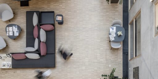 Installasjonsgulv med åpnet gulvmodul som viser teknisk føringsvei i et moderne rom med betongvegg og tregulv.